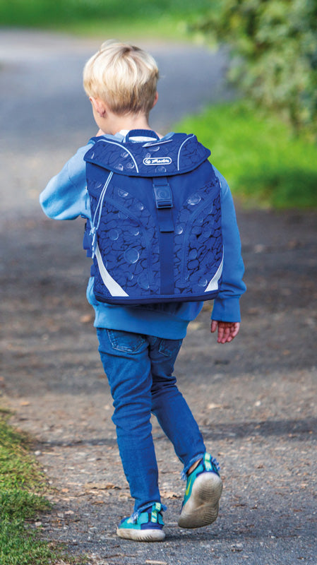 Junge-mit-Herlitz-Schulranzen-SoftLight-Plus-Deep-Sea-blau-400811344546-auf-einem-Weg-im-Park